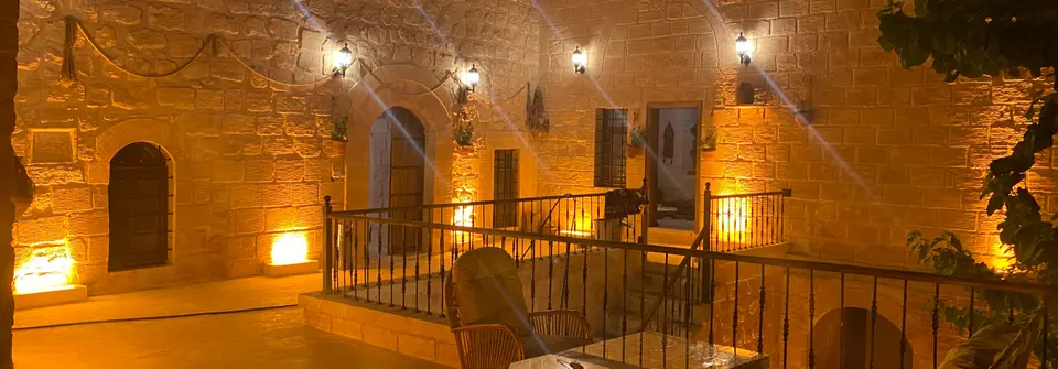 The mansion's lit courtyard with stone arches