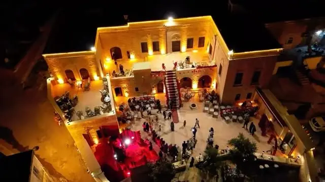 Luftaufnahme einer Feier bei Nacht im Innenhof des Herrenhauses