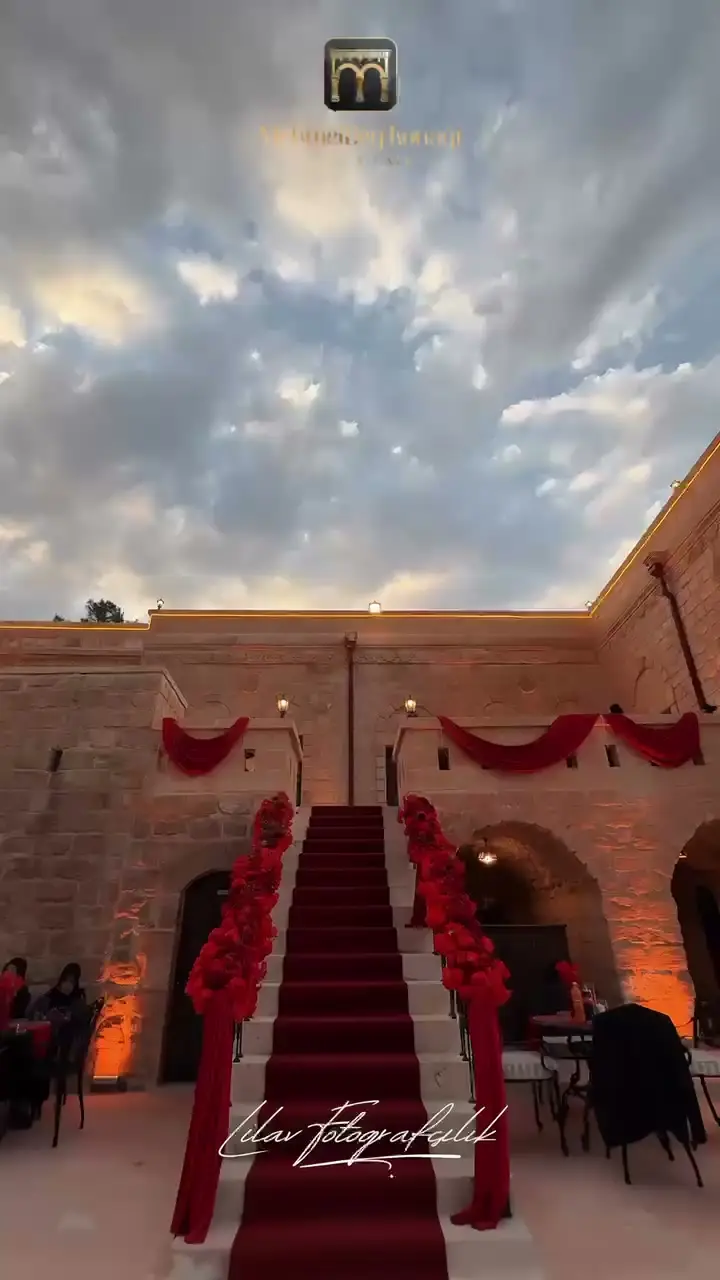 Una scala in pietra decorata con fiori e un tappeto rosso