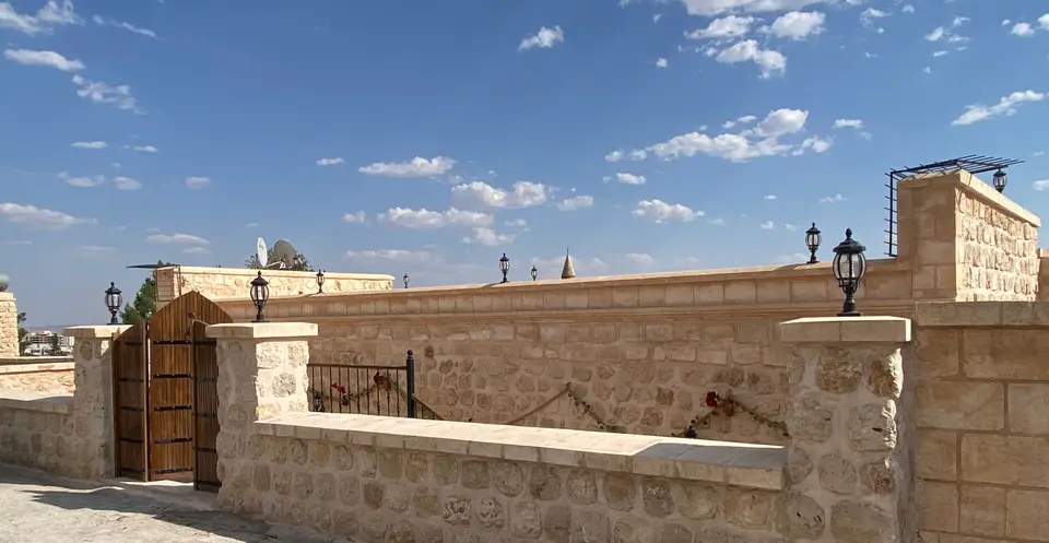 Die Dachterrasse des Herrenhauses bei Tageslicht mit den Steinbauten von Midyat